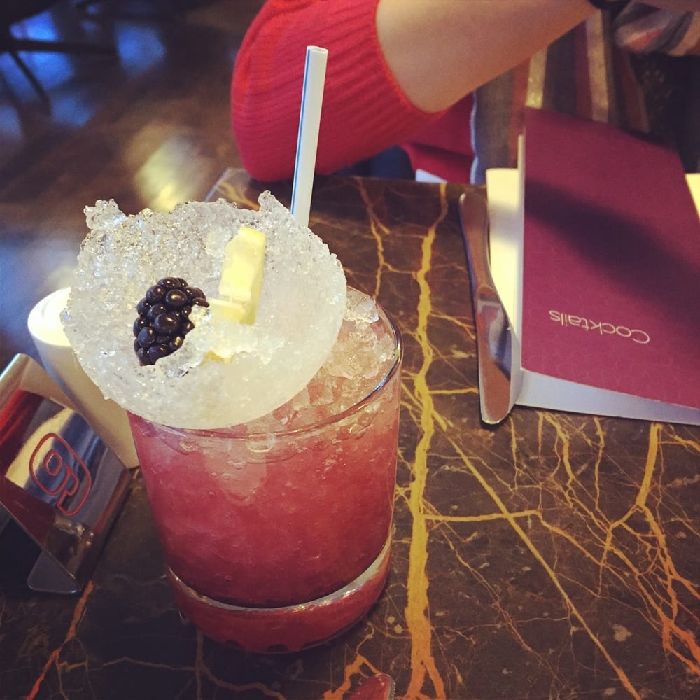 a drink with ice and a berry on top