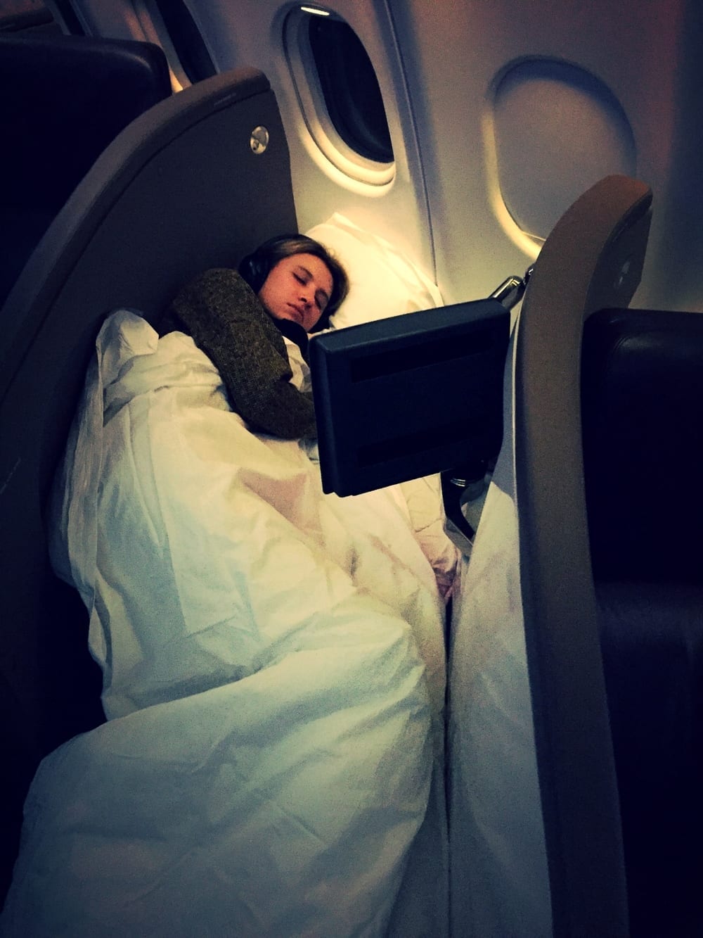 a woman sleeping in an airplane