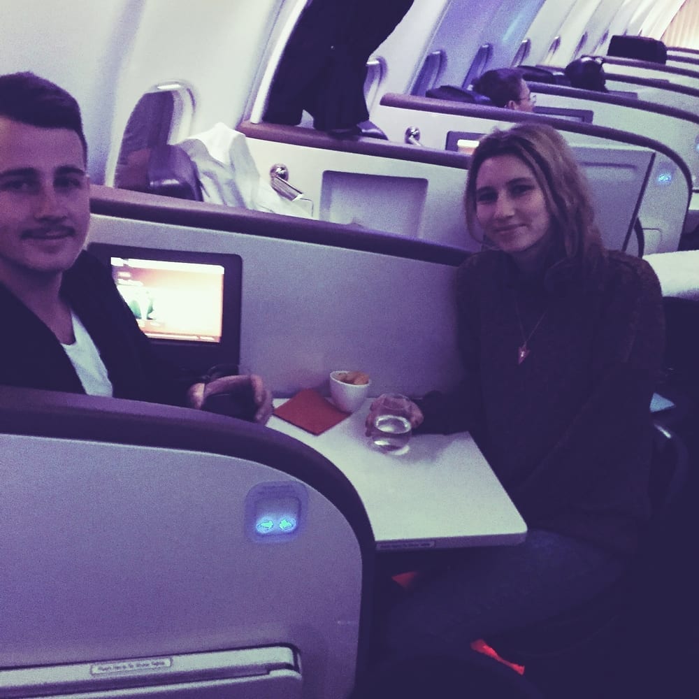 a man and woman sitting at a table in an airplane