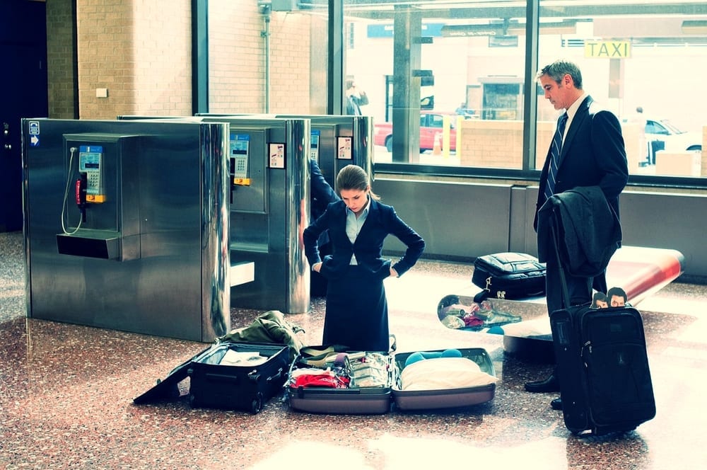 a man and woman standing in a suitcase
