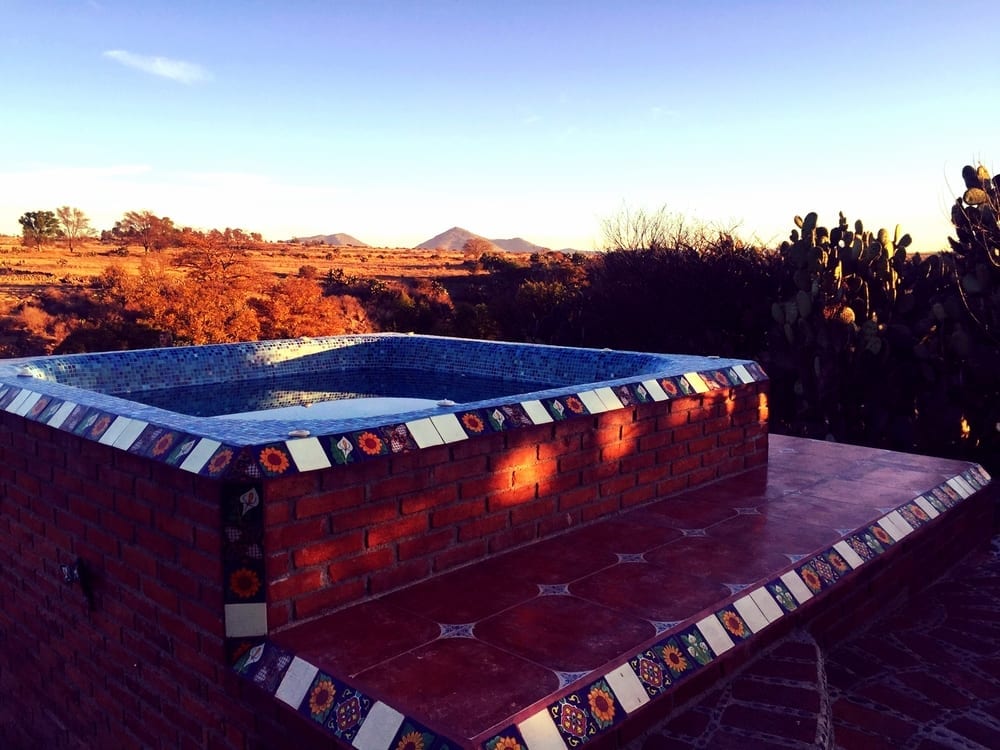 a brick hot tub with a tile edge