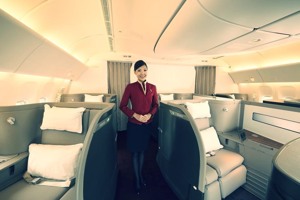 a woman standing in a cabin of an airplane