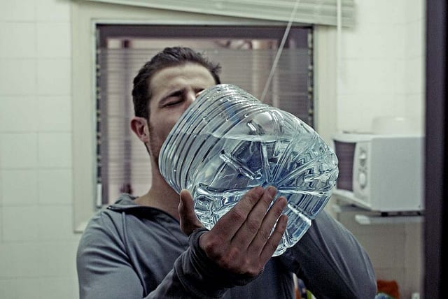 a man holding a large plastic bottle of water