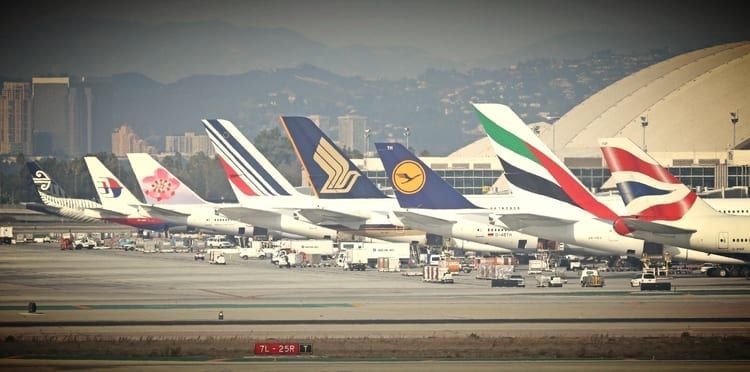 a group of airplanes parked at an airport