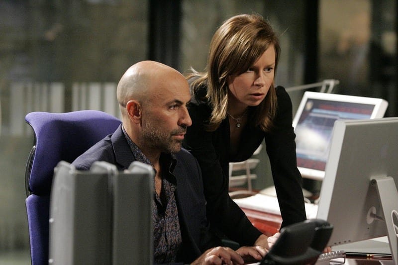 a man and woman looking at a computer