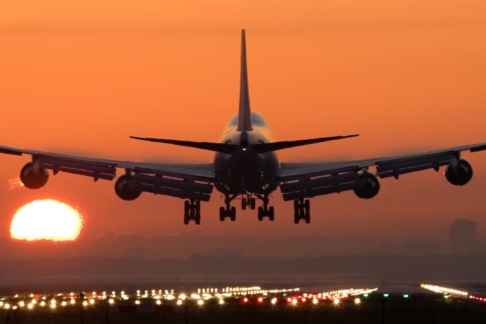 an airplane taking off at sunset