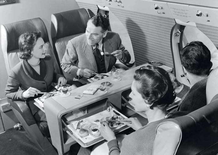 a group of people sitting in an airplane eating