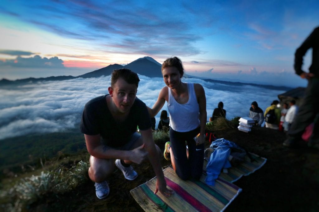 a man and woman kneeling on a mountain top