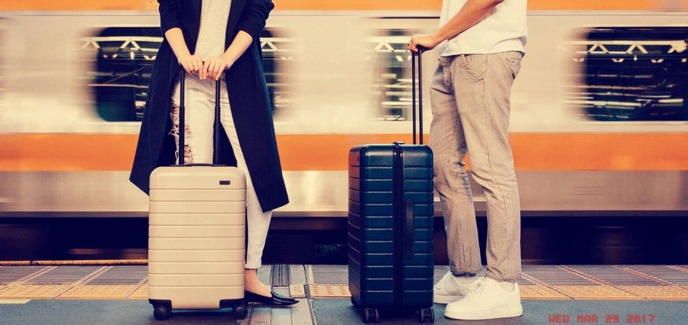 a man and woman standing next to luggage
