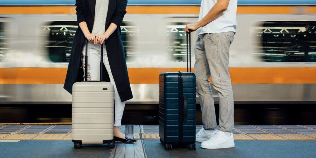 a man and woman standing next to luggage