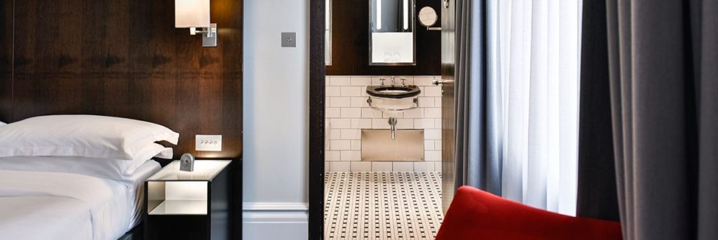 a bathroom with a sink and a red chair