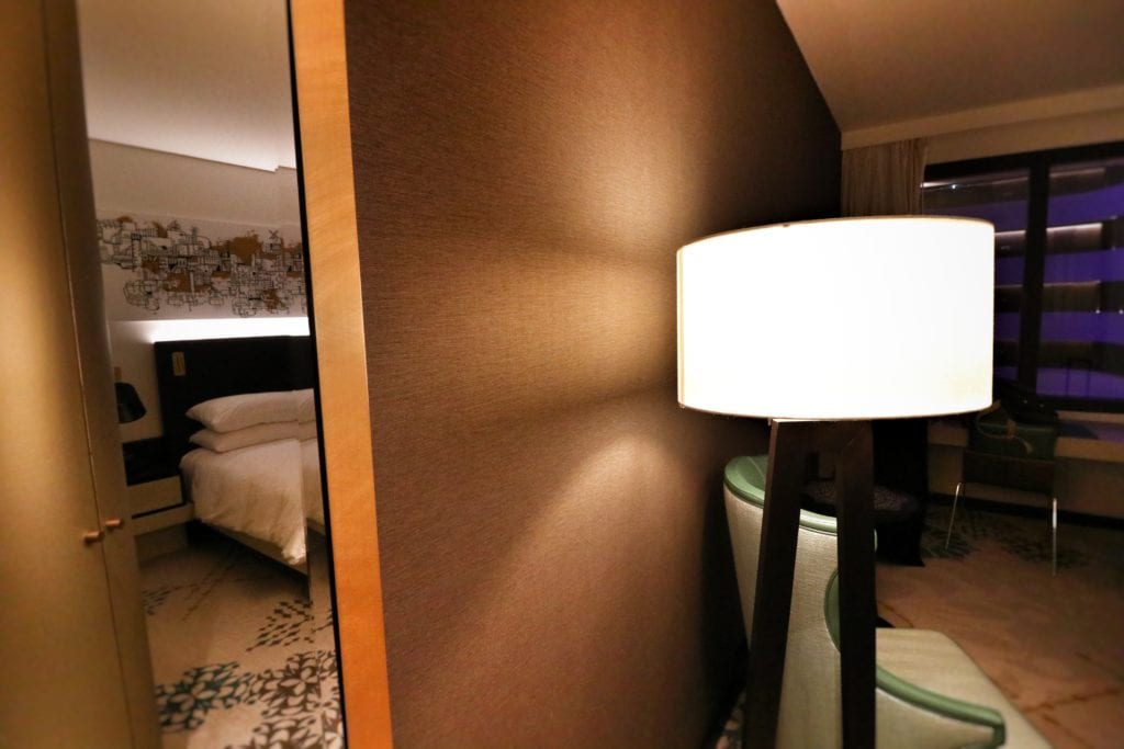 a lamp next to a bed