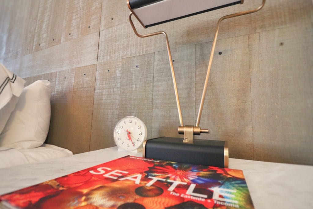 a table with a lamp and a magazine on it