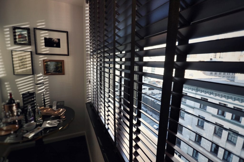 a window with blinds and a desk