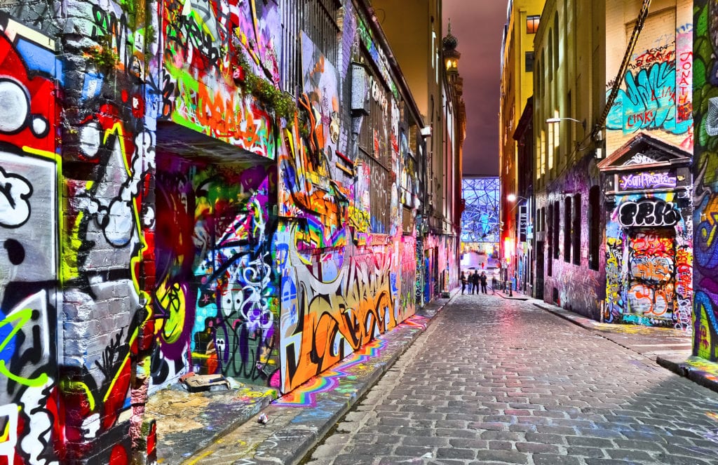 a street with colorful graffiti on the walls