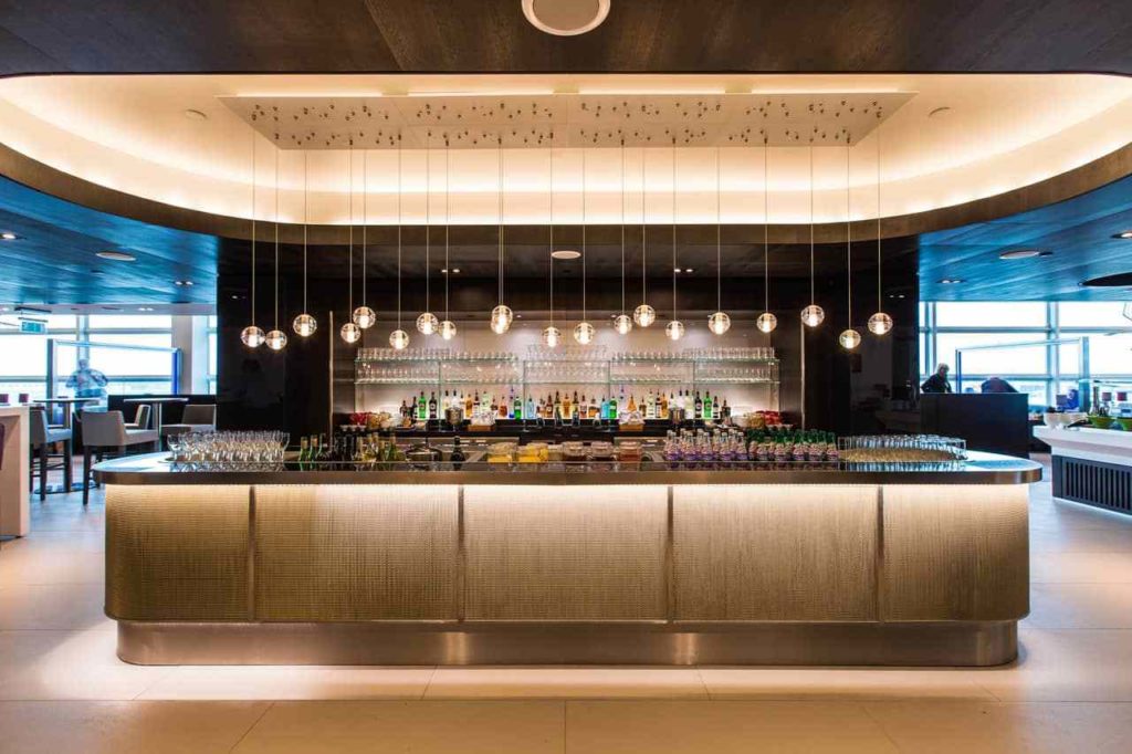 a bar with many bottles and glasses from the ceiling