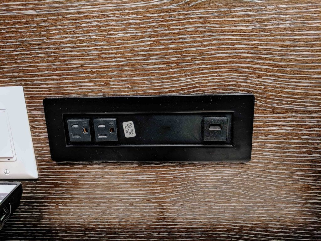 a black rectangular outlet with a black rectangle on a wood surface