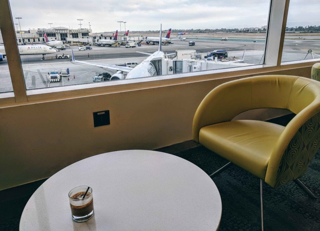 a table and chairs in a room with an airport runway and planes