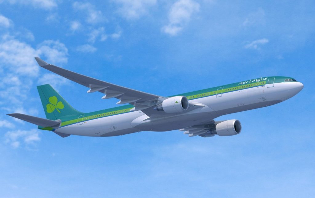 a green and white airplane flying in the sky