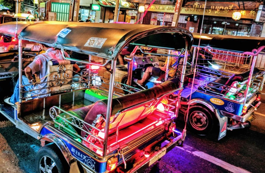 a group of tuk parked on a street
