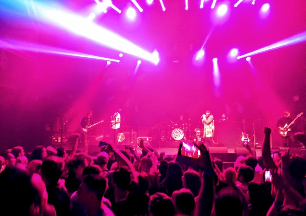 a group of people on a stage with a crowd of people in the background