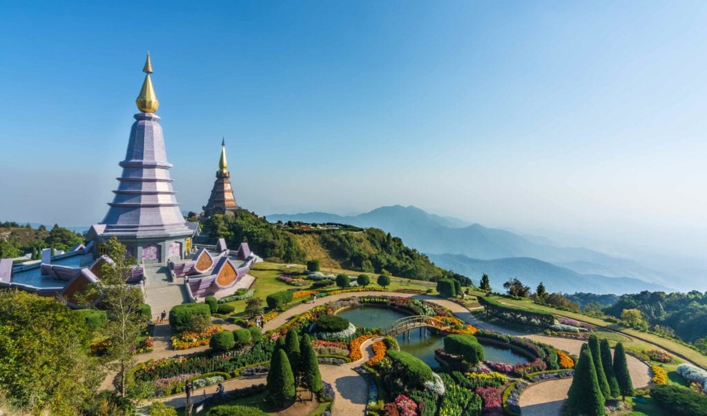 a landscaped garden with Doi Inthanon and a pond