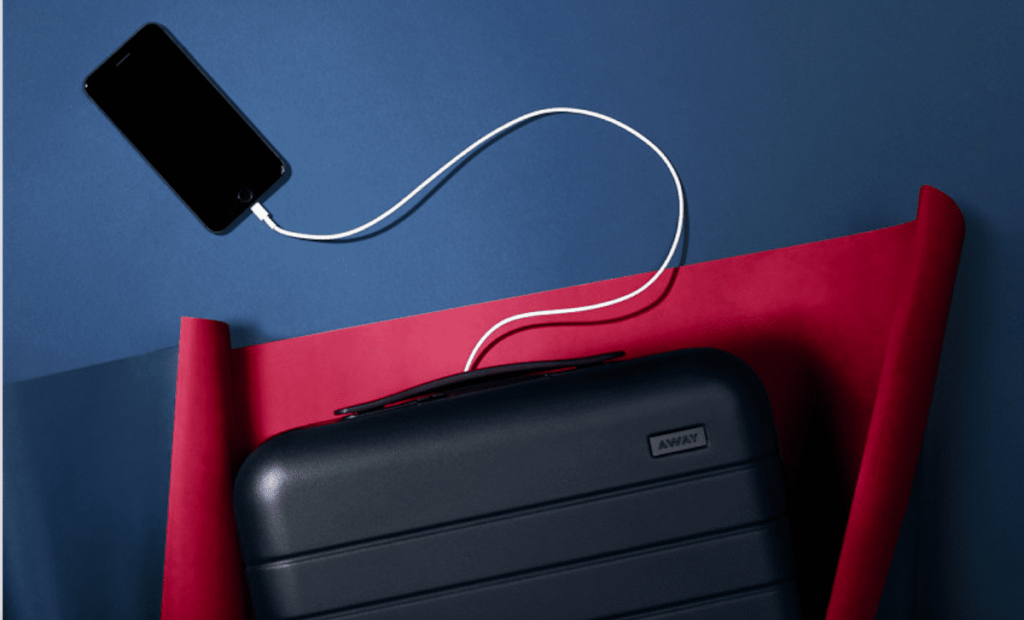 a phone charging from a suitcase