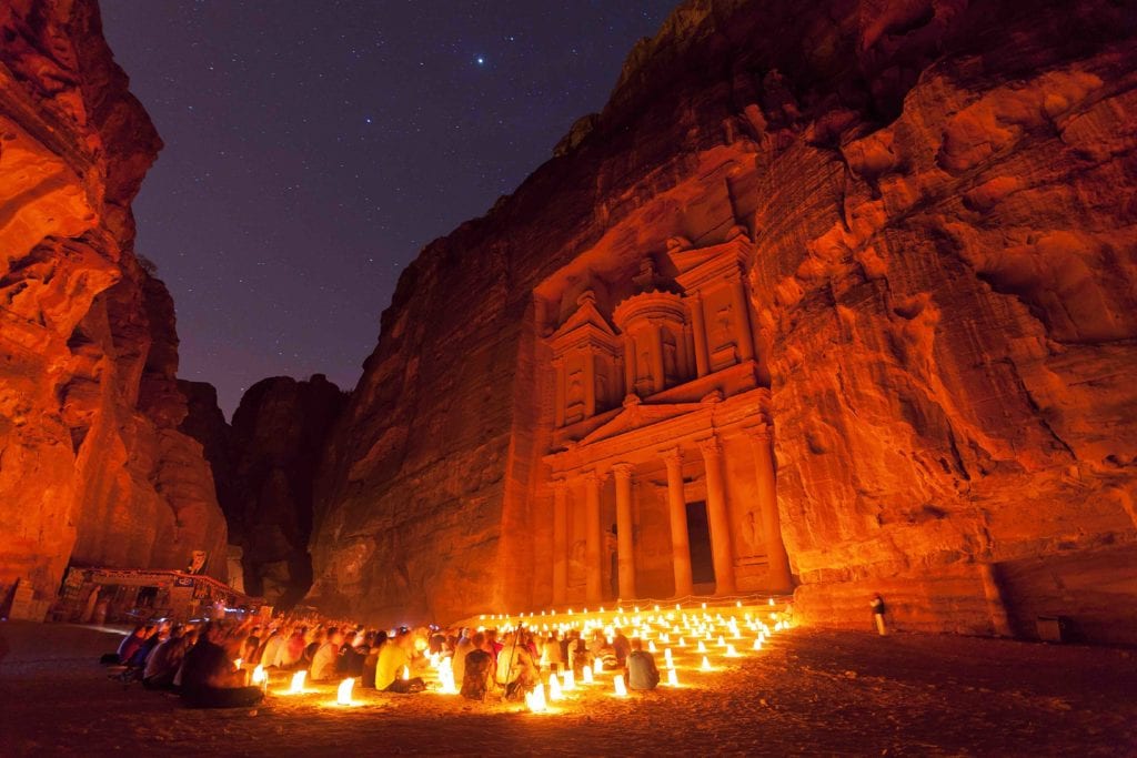people sitting in front of Petra with candles