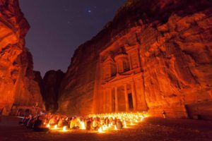 people sitting around Petra with candles in front of it