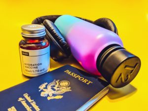 a passport and water bottle with headphones