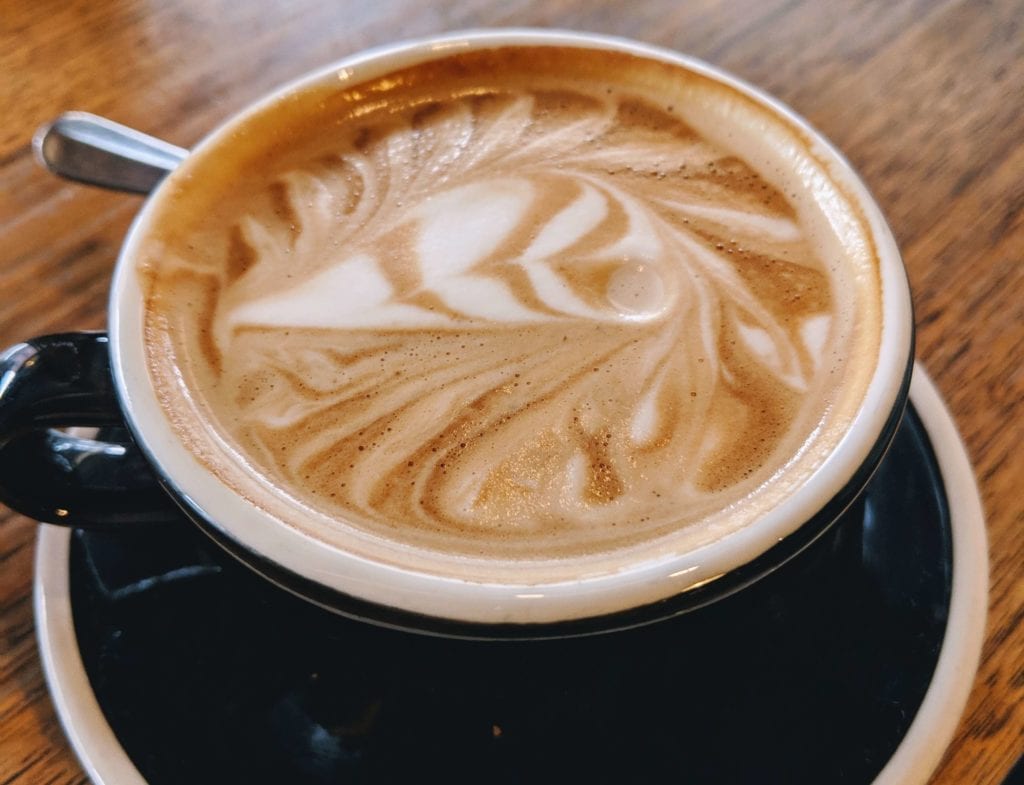 a cup of coffee with a swirl in the foam