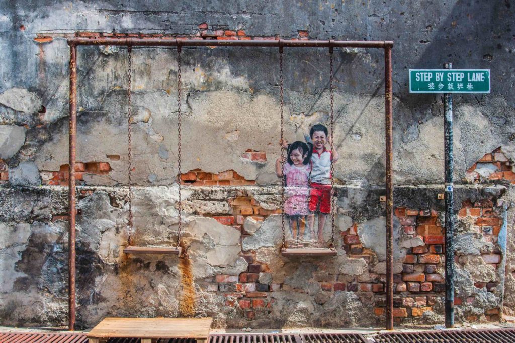 a mural of two children on a swing