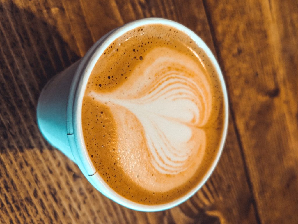 a cup of coffee with a heart shaped foam