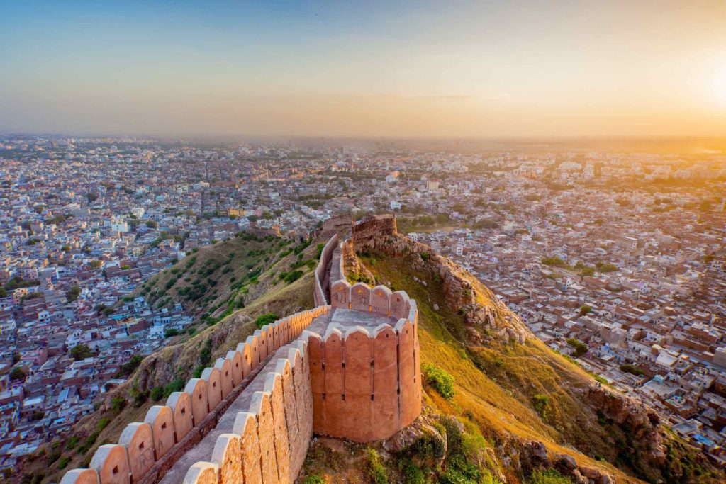 a wall on a hill with a city in the background