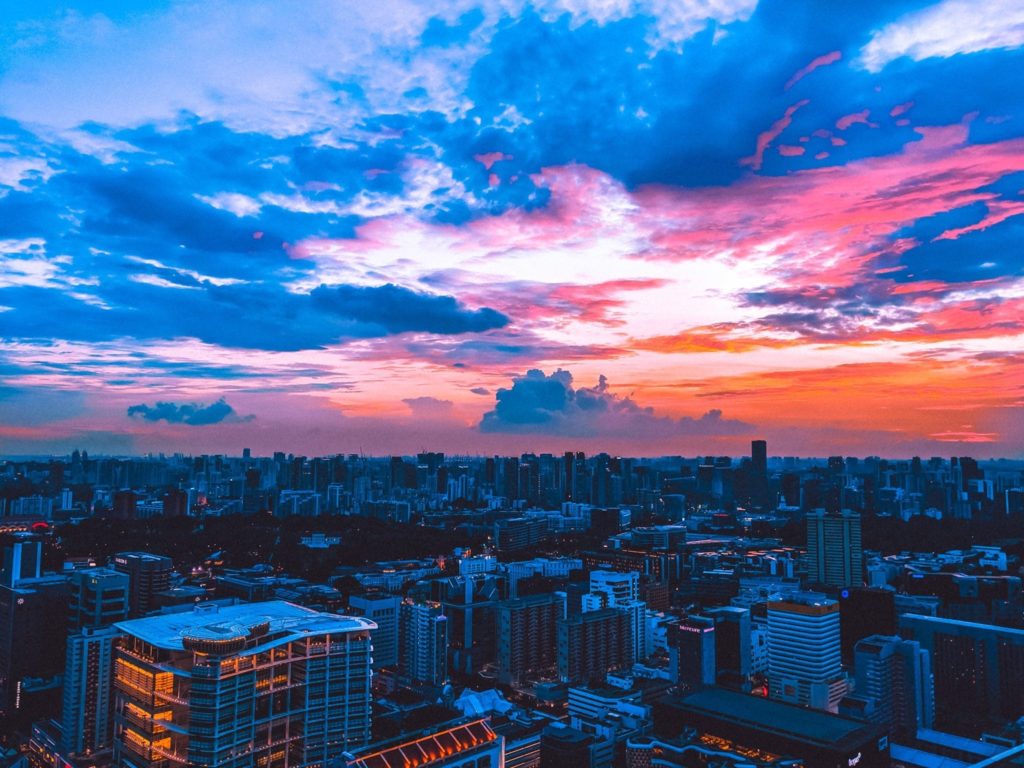 a cityscape with a colorful sky