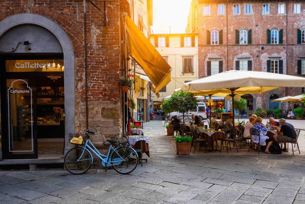 a group of people sitting at tables outside a building