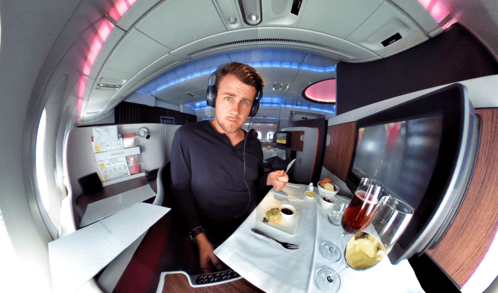 a man sitting at a table with food and headphones