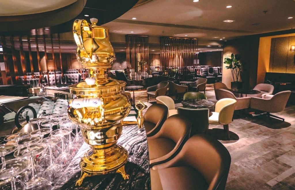 a room with a gold trophy on top of a marble table with chairs