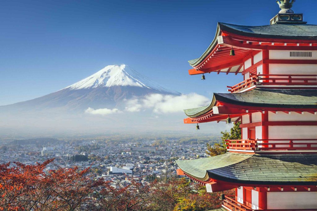 a red pagoda with Mount Fuji in the background