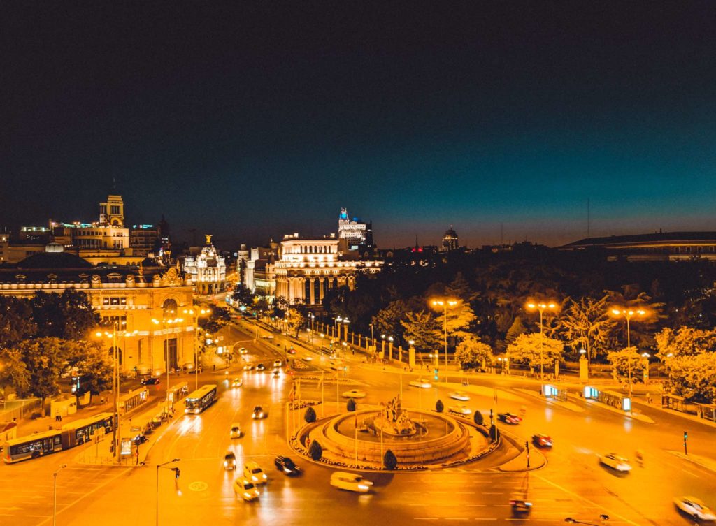 a city street with cars and buildings at night