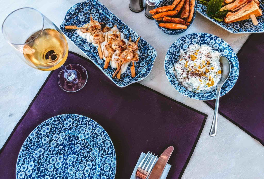 a table with plates of food and a glass of wine