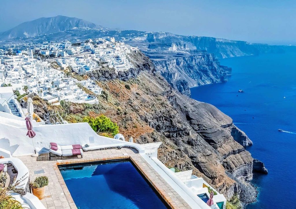 a pool on a cliff overlooking a town
