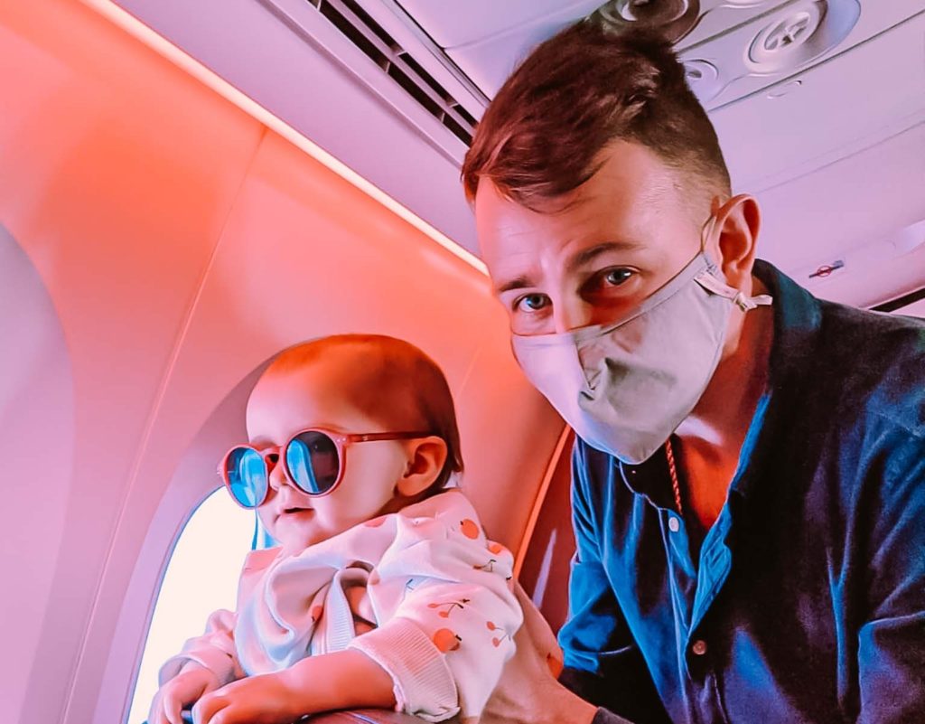 a man wearing a mask and holding a baby