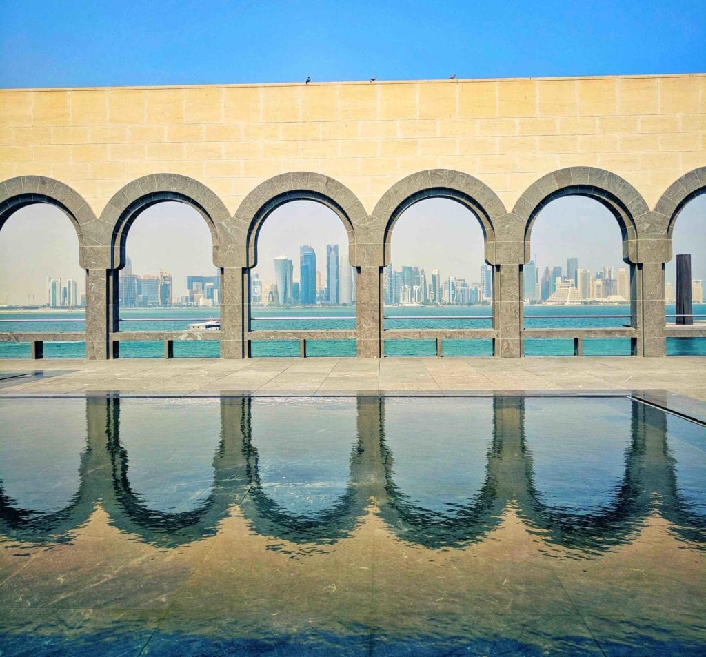 a building with arches and water in the background