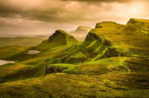 a green hills with Quiraing in the distance