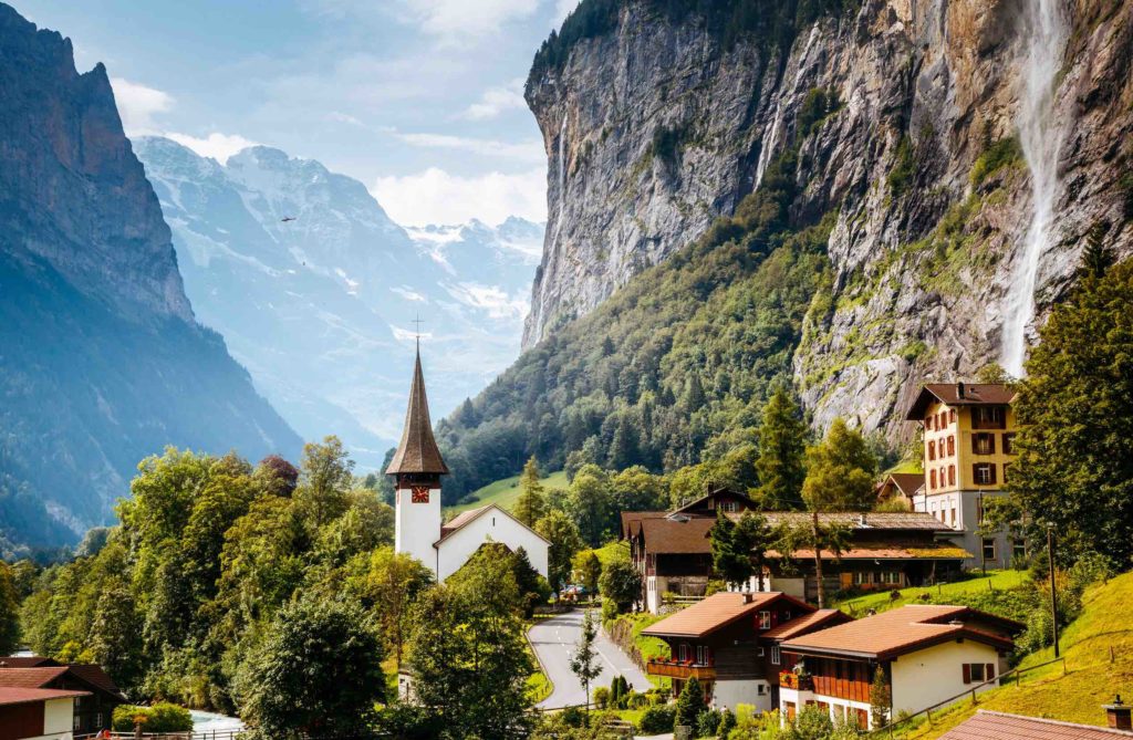 a town in the mountains with Staubbach Falls in the background