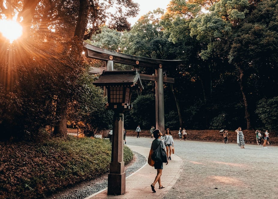 a woman walking under a wooden arch