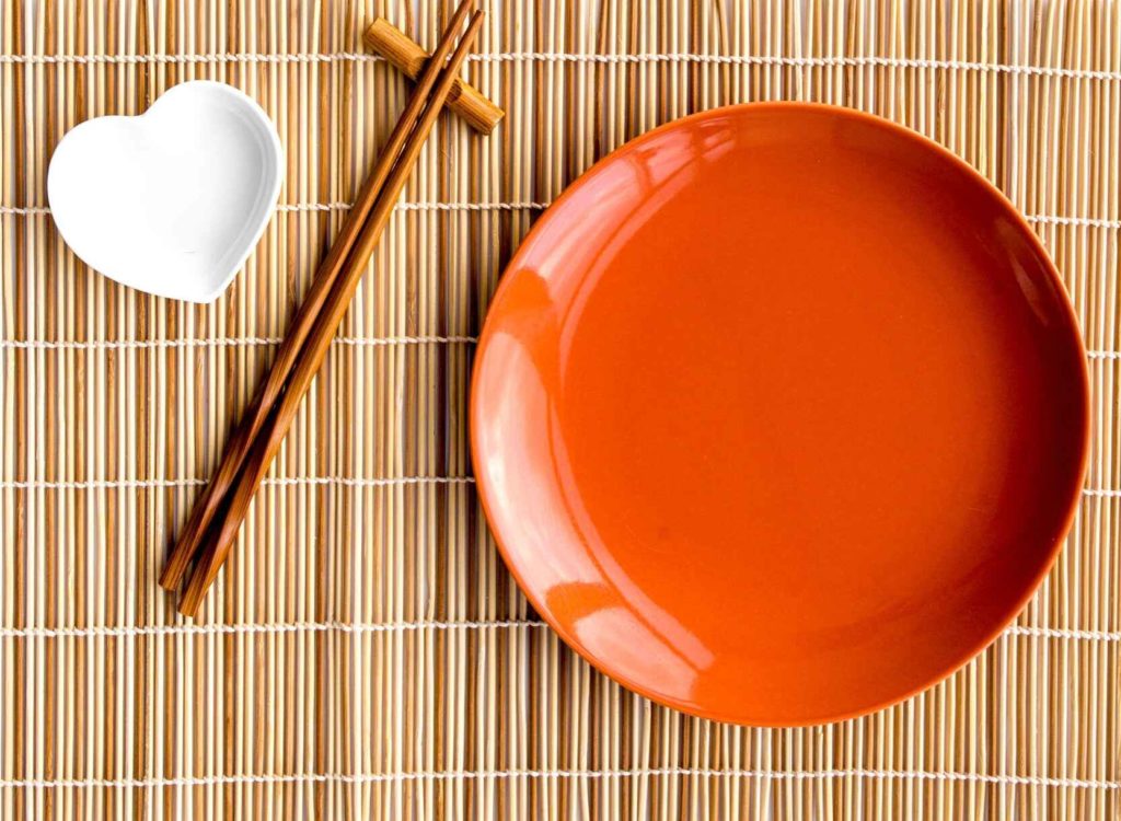 a plate and chopsticks on a mat