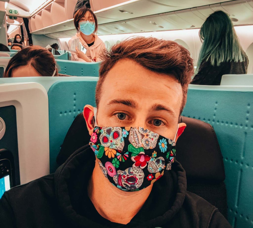 a man wearing a mask on an airplane