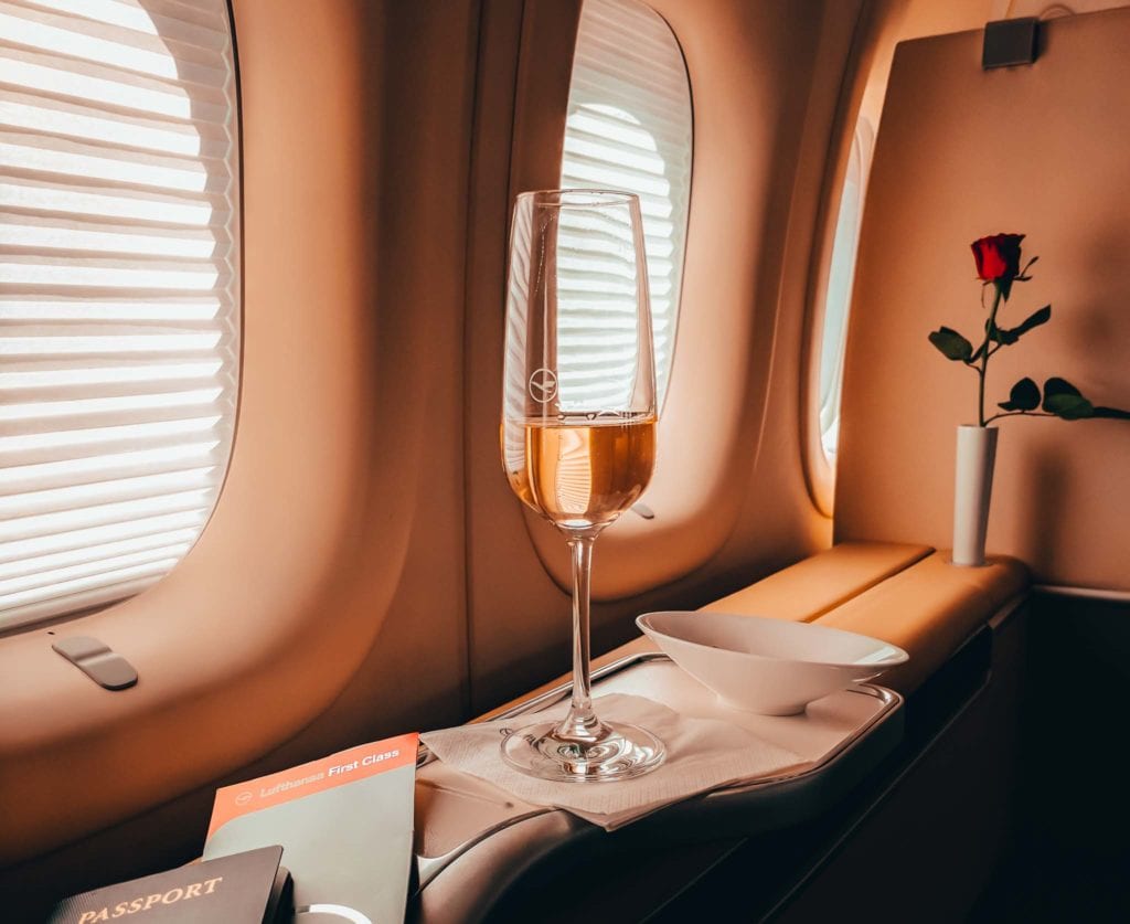 a glass of wine on a tray in a plane